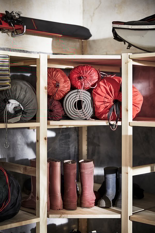 Wooden storage shelves with red bags, boots, and sports gear; IVAR system.