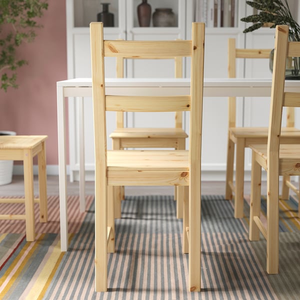 Wooden chairs around dining table on striped rug; durable, safe for home use.