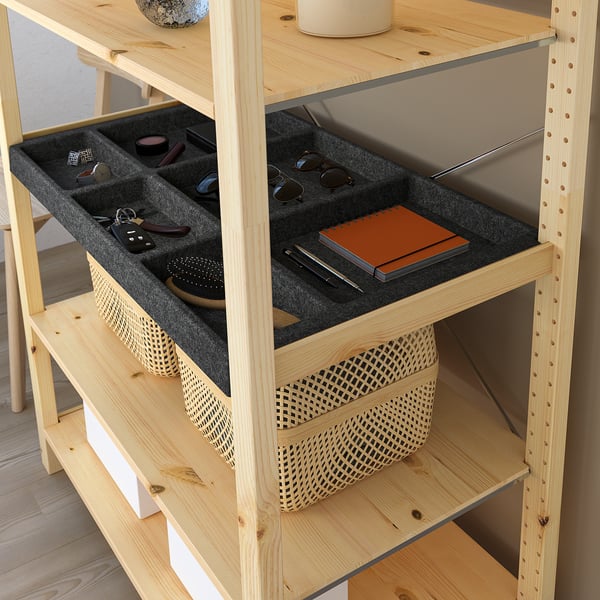 Wooden shelf with felt compartments holding sunglasses, keys, and notebook.