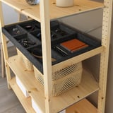 Wooden shelf with felt compartments holding sunglasses, keys, and notebook.