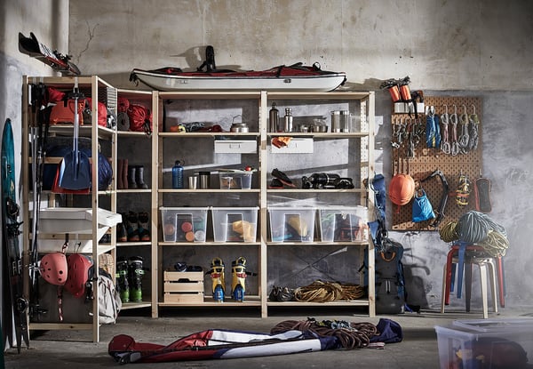 Garage with IVAR wood shelves stocked with sports gear, helmets, and outdoor equipment.