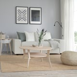 Modern living room with sleek JAKOBSFORS light wood coffee table, round, white couch, blue wall, and natural decor.