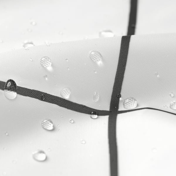 Water droplets bead on shower curtain surface, demonstrating repellent quality.