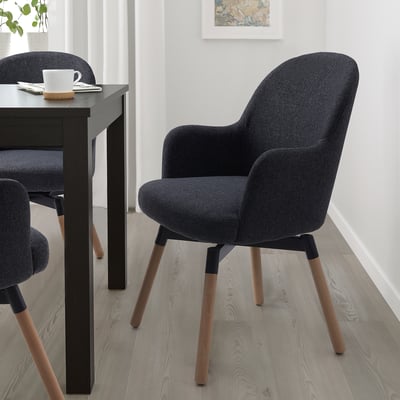 JANOLOF grey swivel chair fits neatly under dark table. Comfortable upholstery, wooden legs, cozy for long dining.