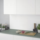 Modern kitchen counter with herbs, bowls, and plants on a durable laminate top.