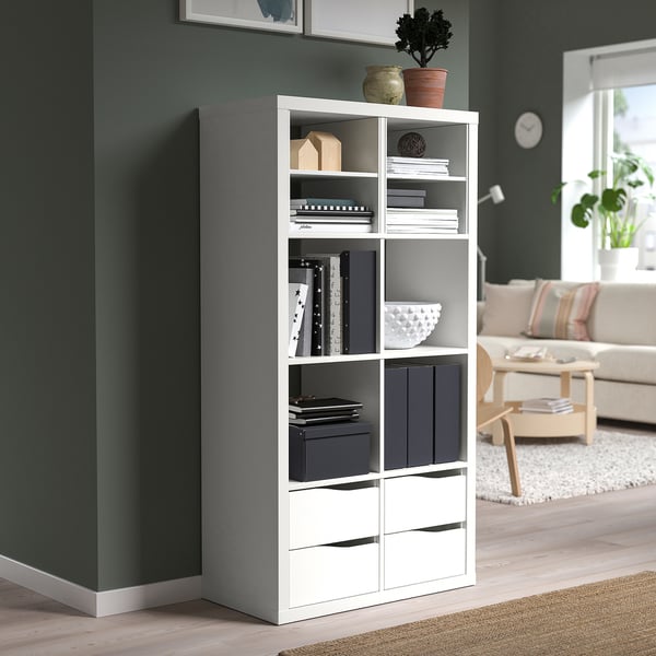 White KALLAX shelf with books, decor, and storage in living room.