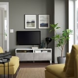Modern living room with KALLVIKEN tv stand, yellow chairs, and green plant.