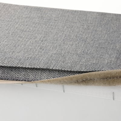 This image shows a gray KIVIK footstool cover with a herringbone pattern. Its machine washable and designed to be easily removed.