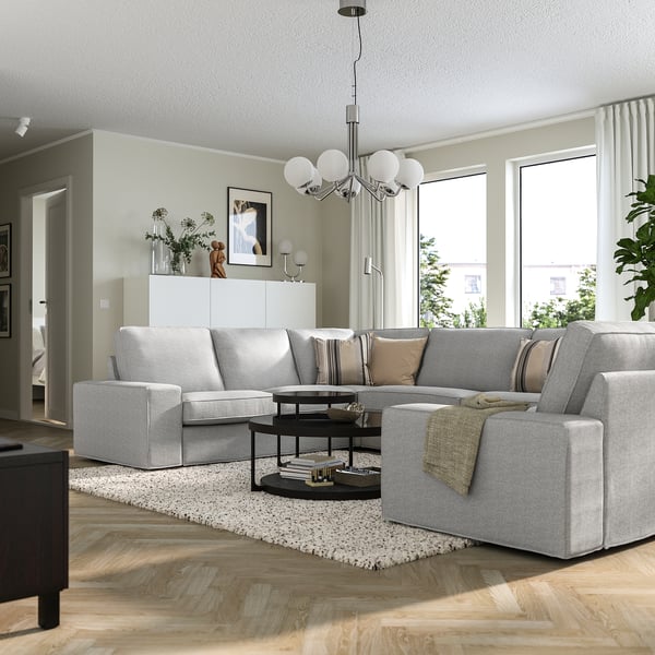KIVIK grey sofa with 3-seat & chaise, wood floors, large windows, black coffee table.