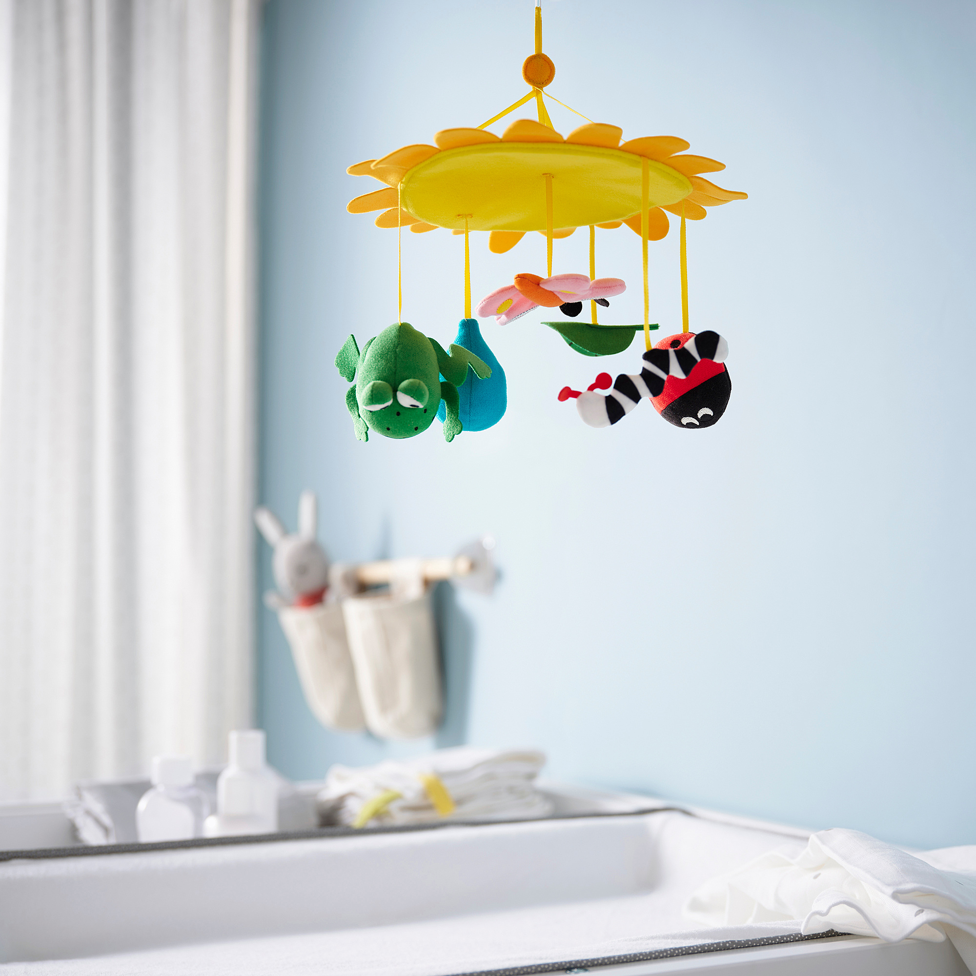 Yellow baby mobile with frog & bee for visual stimulation.