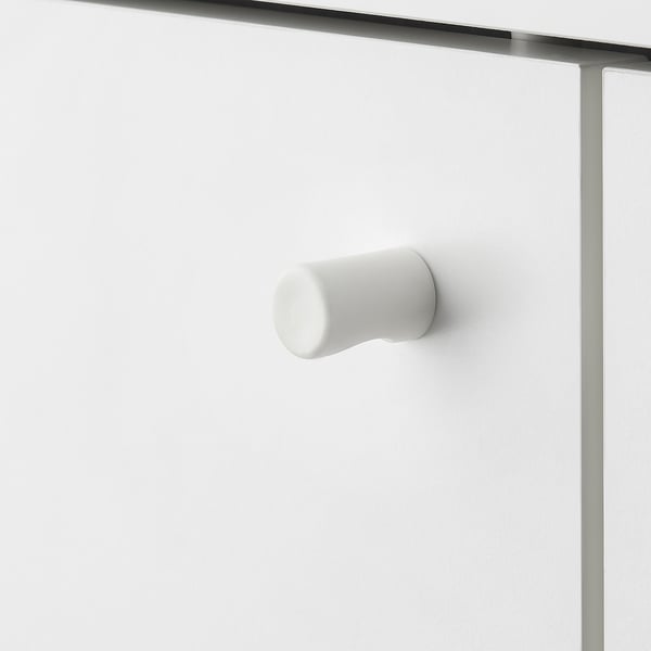 Modern white door handle on sleek cabinet.