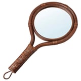 A KLIBBAL hand mirror with a brown rattan frame, curved handle, and clear glass.
