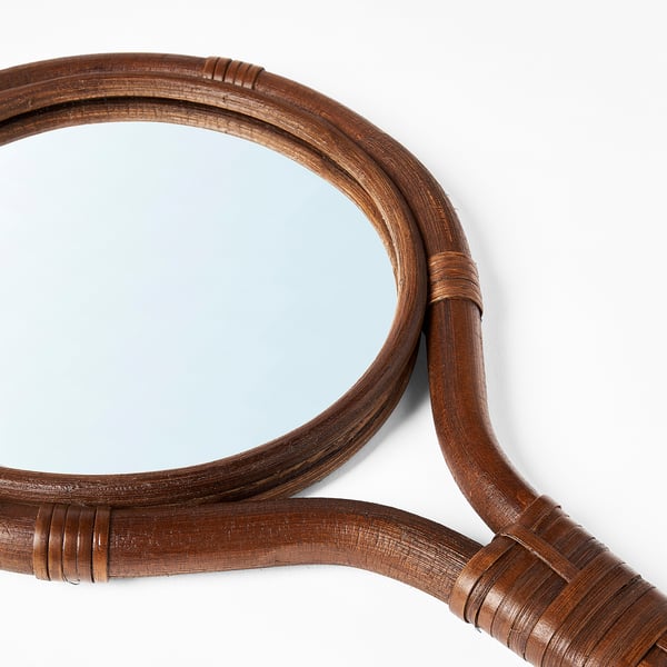 Crafted rattan-framed mirror shows expert handiwork; curves elegantly, reflects light beautifully.