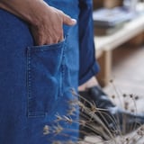 Hand in blue denim pocket, likely part of KLIPPAN sofa cover.