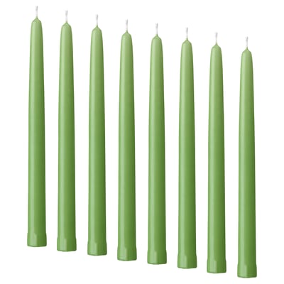 Eight green KLOKHET candles in a row, tall and straight, uniform color and shape, made of stearin.