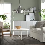 Modern living room with KNAPPHIRS rug, grey couch, and green walls.