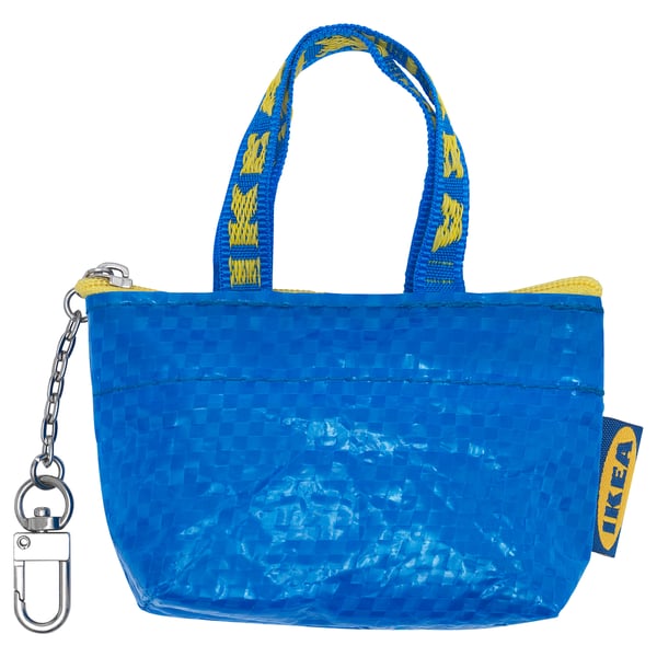 A blue KNÖLIG keychain bag. It has a zip closure and a metal carabiner for attachment.
