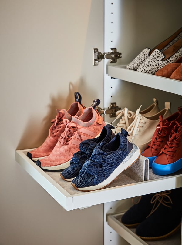 White closet shelf with pink, blue, and beige sneakers neatly organized.