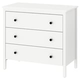 A white KOPPANG chest of drawers with three drawers and black knobs, made of fiberboard and particleboard, designed for safe wall anchorage.