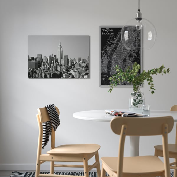 Modern dining area with ny skyline art, map, and greenery.