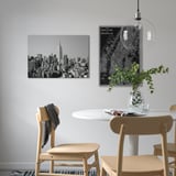 Modern dining area with ny skyline art, map, and greenery.
