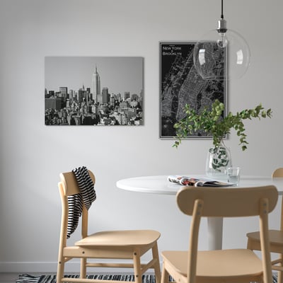 Modern dining area with ny skyline art, map, and greenery.