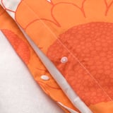 Bright orange duvet cover with large, detailed floral patterns, featuring fine stitching and quality fabric.