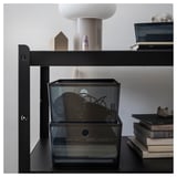 Black KUGGIS box with lid, made of recycled pet plastic, square shape, storing miscellaneous items, stacked on shelf.