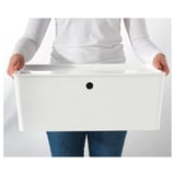 Person holding white storage box with lid.
