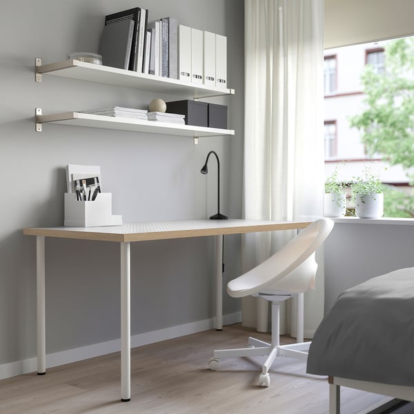 Modern home office setup with LAGKAPTEN desk, white chair, and bookshelves. Clean, minimalist design with light wood and metal.