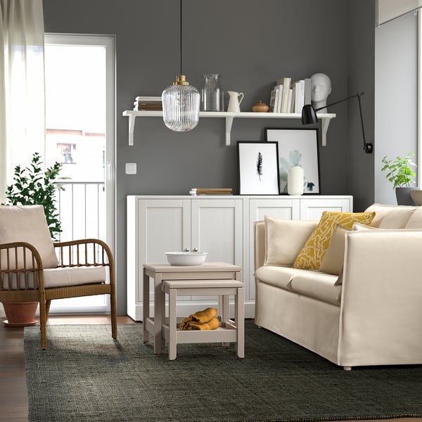 Modern living room with LANDBANA jute rug, gray walls, white furniture, and plants.