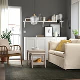 Modern living room with LANDBANA jute rug, gray walls, white furniture, and plants.