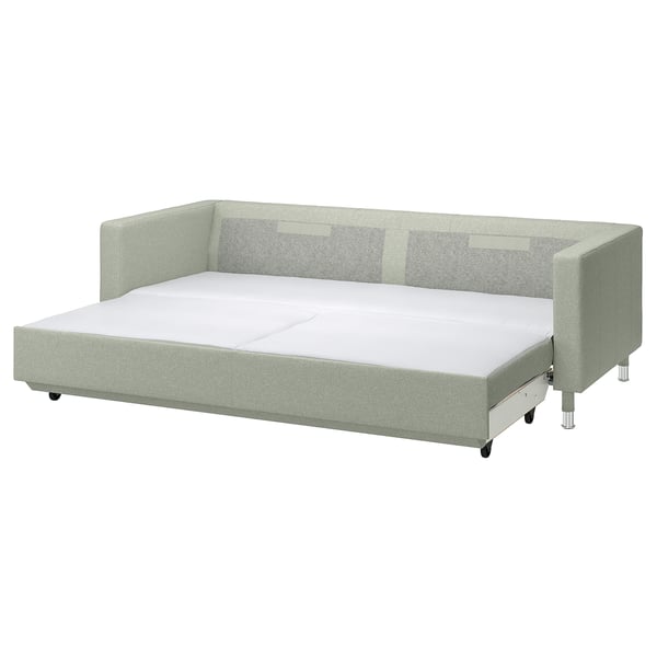 A green convertible sofa-bed with chrome legs.