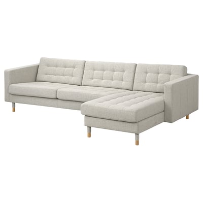 Light gray modern sectional sofa with wooden legs, tufted design.
