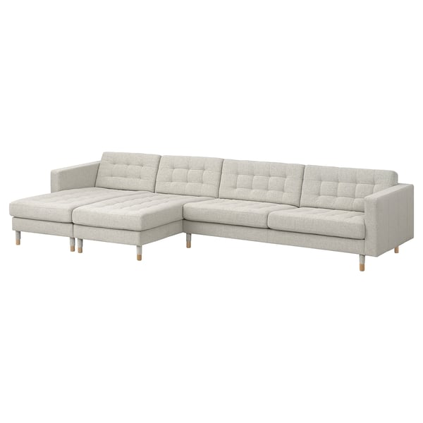 A modern, light gray l-shaped couch with wooden legs, featuring a tufted backrest and removable armrests.