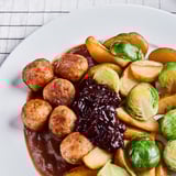 Frozen meal with roasted potatoes, chicken meatballs, brussels sprouts, and gravy.
