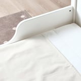 White bed protector, waterproof, cotton and plastic, prevents diaper leakage.