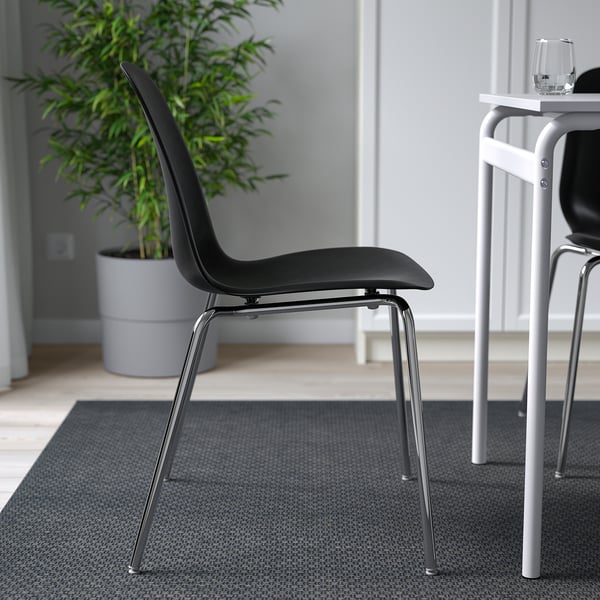 Chic black chair with curved back, chrome legs. Stackable and easy to clean. Perfect for modern dining.