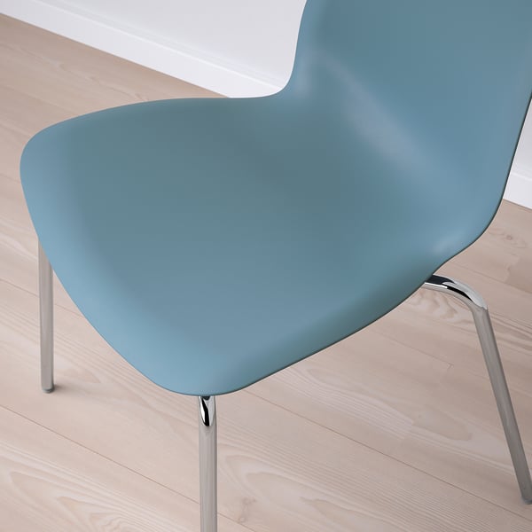 Light blue modern plastic chair with curved seat and metal legs on a light wooden floor.