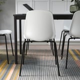 Modern dining set with 3 LIDÅS chairs, black legs, white seats, around minimalist black table on striped rug.