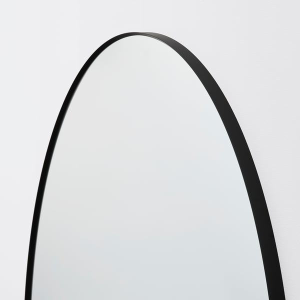 Elegant, round black-framed wall mirror, reflecting a quality finish.