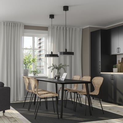 Modern dining room with LISABO table and wicker chairs, pendant lights, near kitchen with tall window.