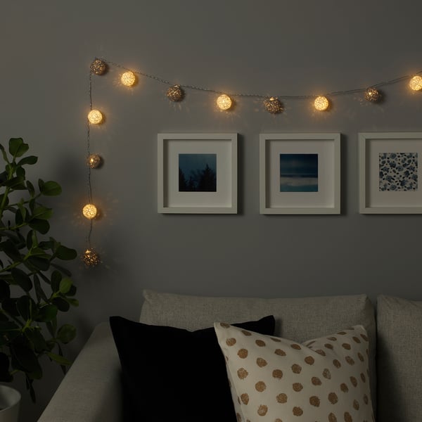 Warm led globe lights above couch for festive atmosphere.