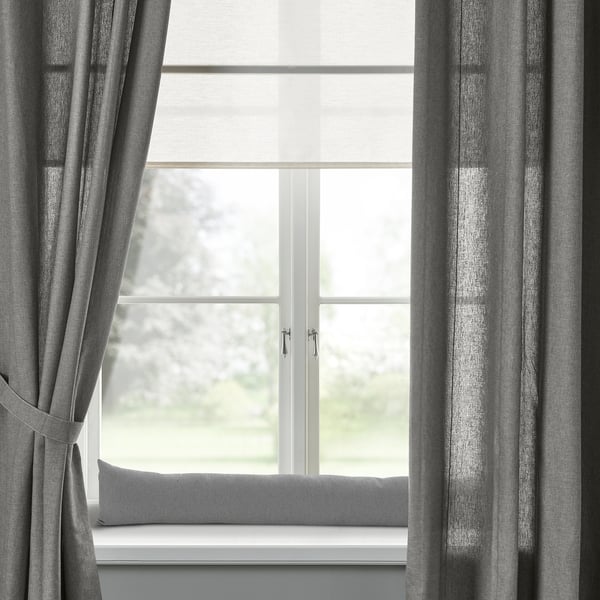 Grey LJUNGSNÄRJA cushion on windowsill with matching curtains, soft light.