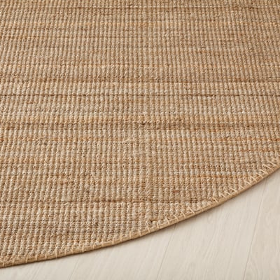 Circular beige jute rug, natural fibers, flatwoven, neutral tones.