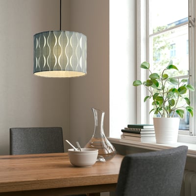 Cozy dining setup with LÖKNÄS lamp, books, and plant.