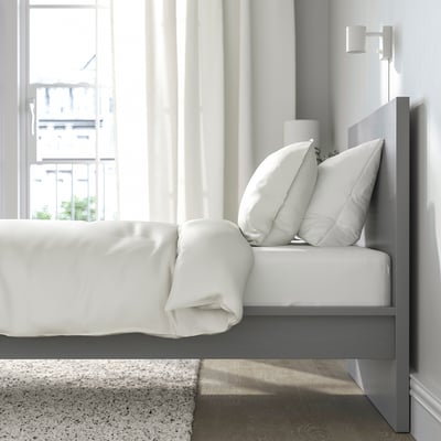 Cozy bedroom with MALM bed, crisp white bedding, and a large window allowing natural light to brighten the room.