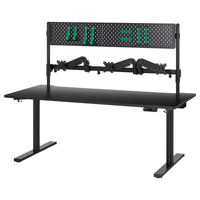 MÅLOMRÅDE gaming desk: black, adjustable height, dual monitor arms, pegboard with green accessories.