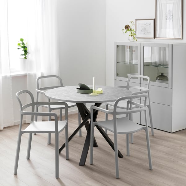 Round modern dining table with 4 grey chairs, ideal for compact spaces. Centered tray with candle.