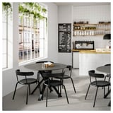 Modern cafe with MARIEDAMM black metal tables and chairs, white tiled walls, large windows, and chalkboard menu.